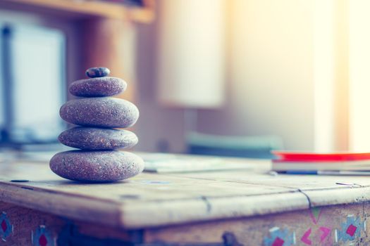 Feng Shui: Stone cairn in the foreground, blurry living room in the background. Balance and relaxation.