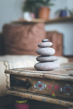 Feng Shui: Stone cairn in the foreground, blurry living room in the background. Balance and relaxation.