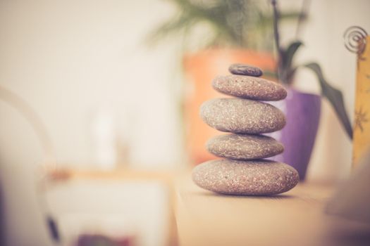 Feng Shui: Stone cairn in the foreground, blurry living room in the background. Balance and relaxation.