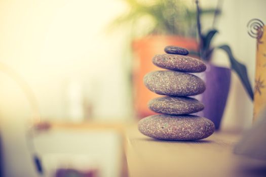 Feng Shui: Stone cairn in the foreground, blurry living room in the background. Balance and relaxation.