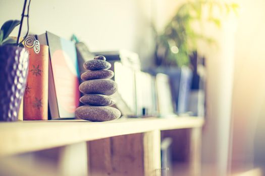 Feng Shui: Stone cairn in the foreground, blurry living room in the background. Balance and relaxation.