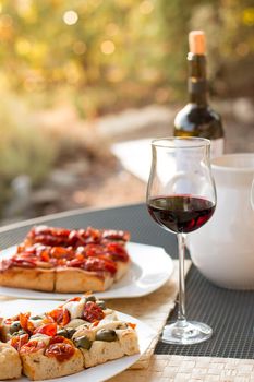 Italian Dinner with red wine, pizza and bread outside. Vacation