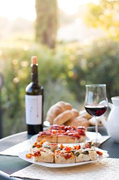 Italian Dinner with red wine, pizza and bread outside. Vacation