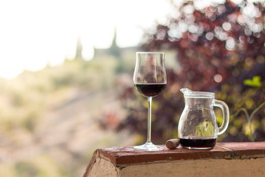 Enjoying a glass of red wine at Tuscany, Italy. Blurry wine yards in the background.