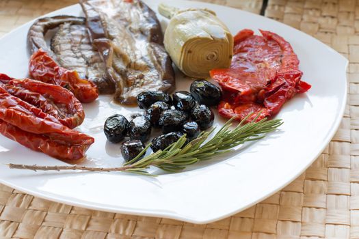 Italian antipasti as dinner appetizer. Tomatoes, Olives, paprika and more.