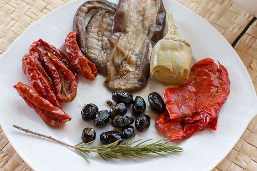 Italian antipasti as dinner appetizer. Tomatoes, Olives, paprika and more.