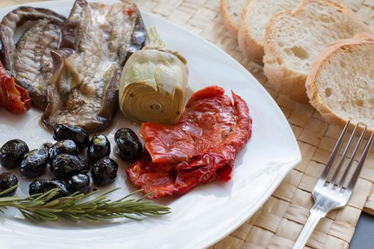 Italian antipasti as dinner appetizer. Tomatoes, Olives, paprika and more.