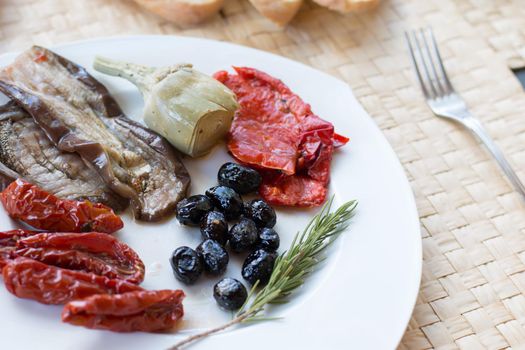 Italian antipasti as dinner appetizer. Tomatoes, Olives, paprika and more.