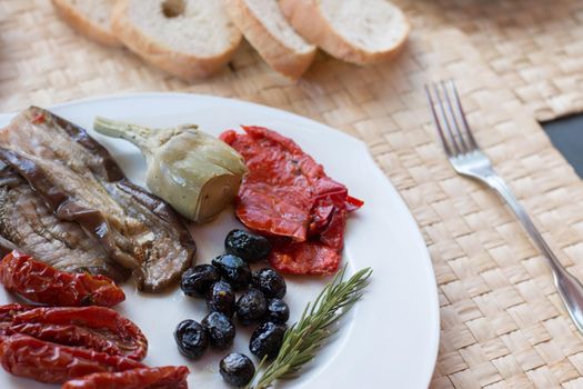 Italian antipasti as dinner appetizer. Tomatoes, Olives, paprika and more.