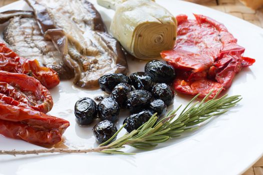 Italian antipasti as dinner appetizer. Tomatoes, Olives, paprika and more.