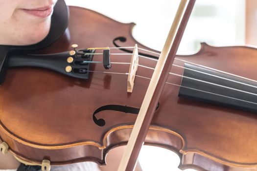Pretty young girl practices on her violin, acoustic music