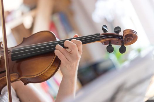 Pretty young girl practices on her violin, acoustic music