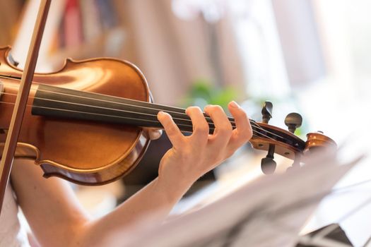 Pretty young girl practices on her violin, acoustic music