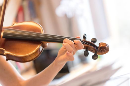 Pretty young girl practices on her violin, acoustic music