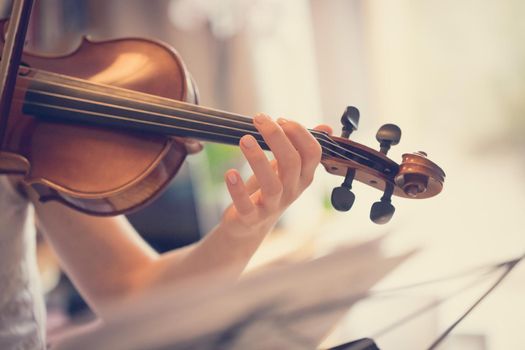 Pretty young girl practices on her violin, acoustic music