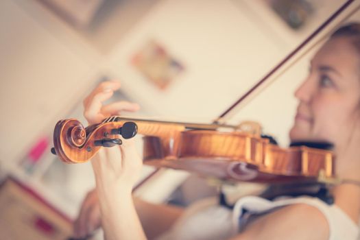 Pretty young girl practices on her violin, acoustic music