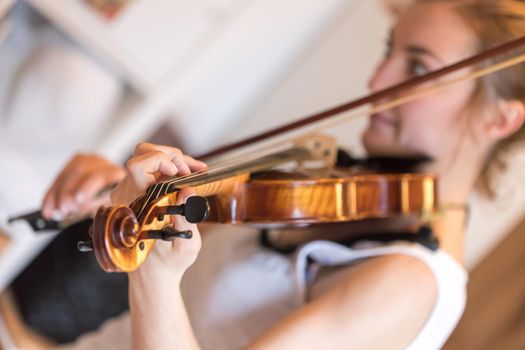 Pretty young girl practices on her violin, acoustic music