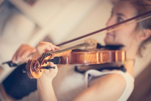 Pretty young girl practices on her violin, acoustic music