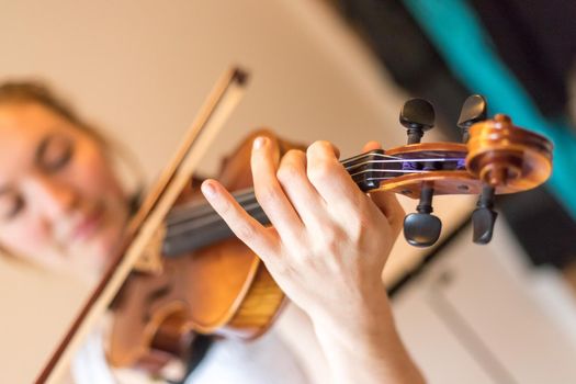 Pretty young girl practices on her violin, acoustic music