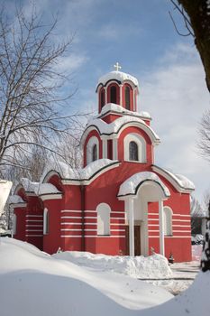 Beautiful snowed red church in the winter, blue sky
