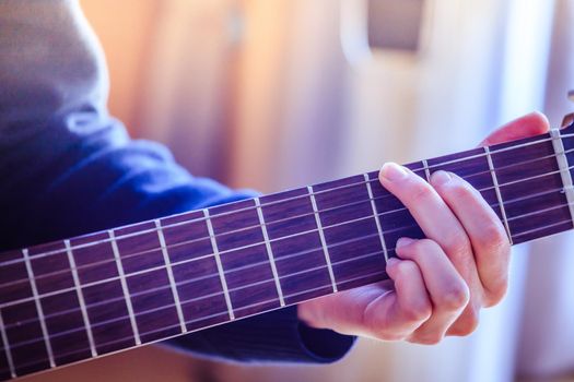 Musician plays a classical guitar, hands, fretboard and fingers