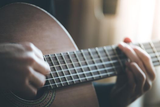 Musician plays a classical guitar, blurry hands, fretboard and fingers