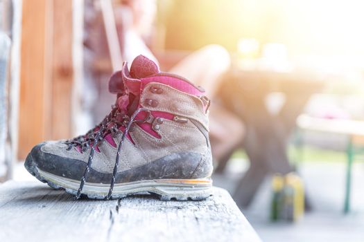 Close up picture of hiking boots on a rustic wooden veranda of an alpine hut