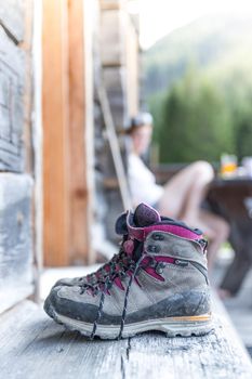 Close up picture of hiking boots on a rustic wooden veranda of an alpine hut