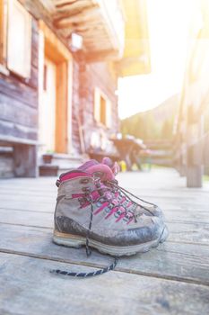 Close up picture of hiking boots on a rustic wooden veranda of an alpine hut