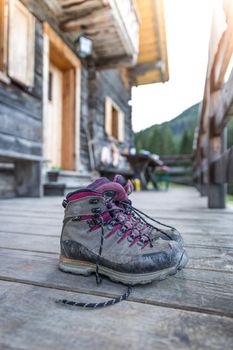 Close up picture of hiking boots on a rustic wooden veranda of an alpine hut