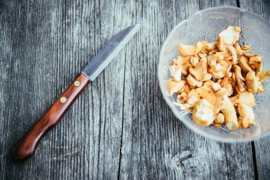 Preparing chanterelle mushrooms on an old rustic wooden table