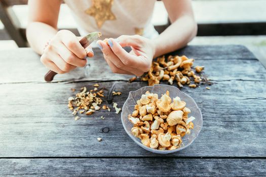 Preparing chanterelle mushrooms on an old rustic wooden table