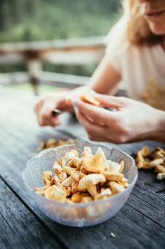 Preparing chanterelle mushrooms on an old rustic wooden table