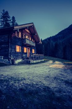 Rustic wooden farm hut in the night. European alps, Austria