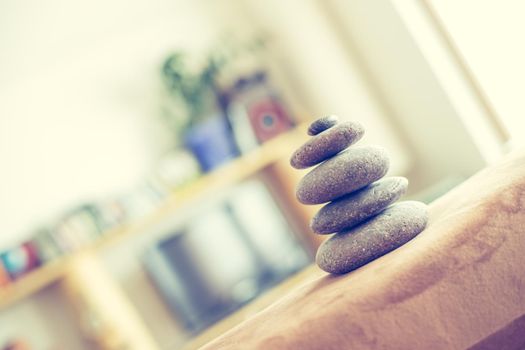 Feng Shui: Stone cairn in the foreground, blurry living room in the background. Balance and relaxation.