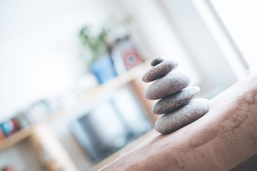 Feng Shui: Stone cairn in the foreground, blurry living room in the background. Balance and relaxation.