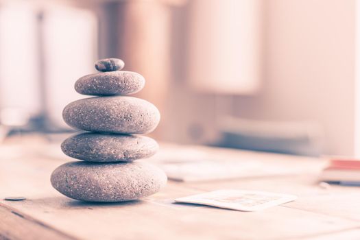 Feng Shui: Stone cairn in the foreground, blurry living room in the background. Balance and relaxation.