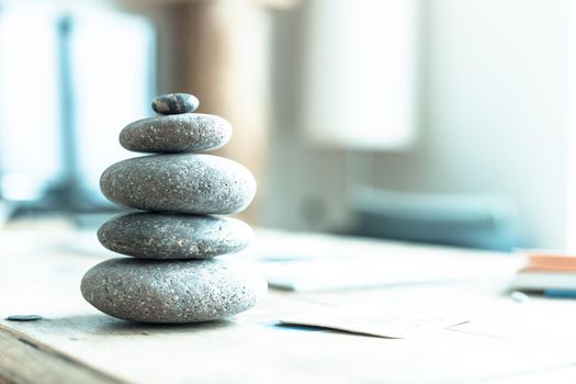 Feng Shui: Stone cairn in the foreground, blurry living room in the background. Balance and relaxation.