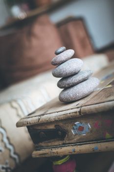 Feng Shui: Stone cairn in the foreground, blurry living room in the background. Balance and relaxation.