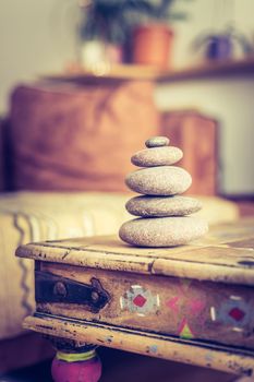 Feng Shui: Stone cairn in the foreground, blurry living room in the background. Balance and relaxation.