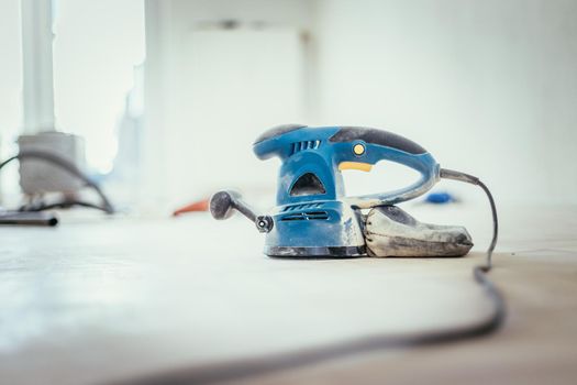 Close up of a sander power tool for DIY on wooden parquet floor
