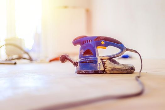 Close up of a sander power tool for DIY on wooden parquet floor