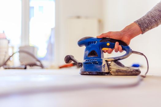 Close up of a sander power tool for DIY on wooden parquet floor