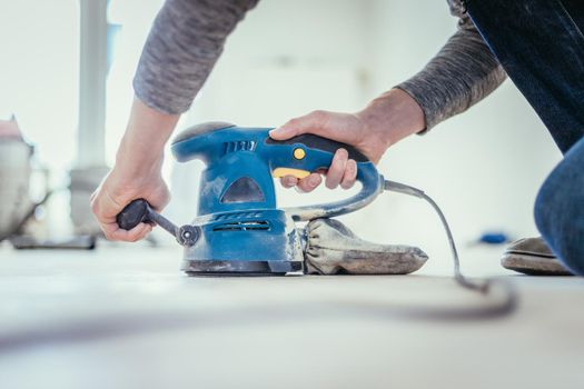 Close up of a sander power tool for DIY on wooden parquet floor