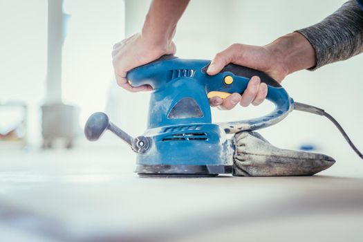 Close up of a sander power tool for DIY on wooden parquet floor