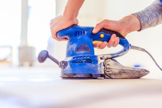 Close up of a sander power tool for DIY on wooden parquet floor