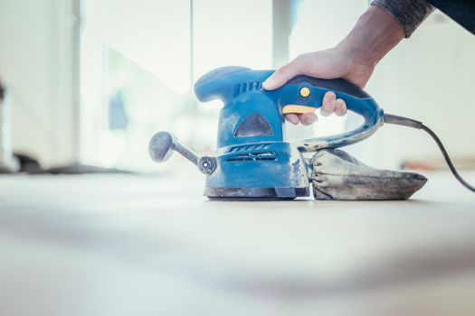 Close up of a sander power tool for DIY on wooden parquet floor