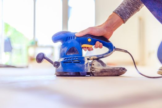 Close up of a sander power tool for DIY on wooden parquet floor