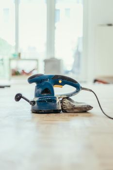 Close up of a sander power tool for DIY on wooden parquet floor