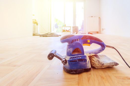 Close up of a sander power tool for DIY on wooden parquet floor